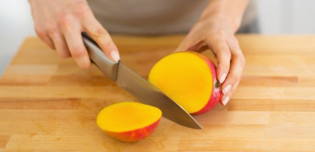mango snijden met een mes op een snijplank