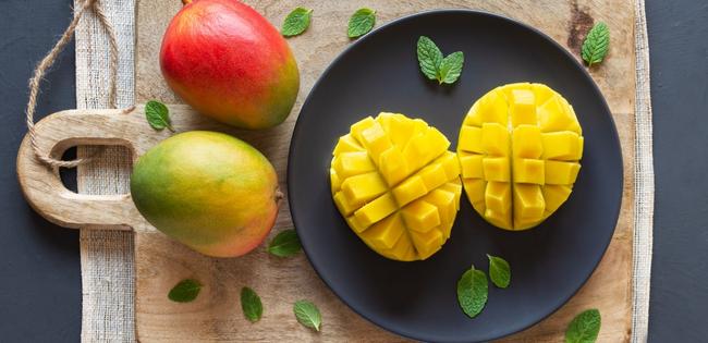 mango vrucht op snijplank met muntbladeren